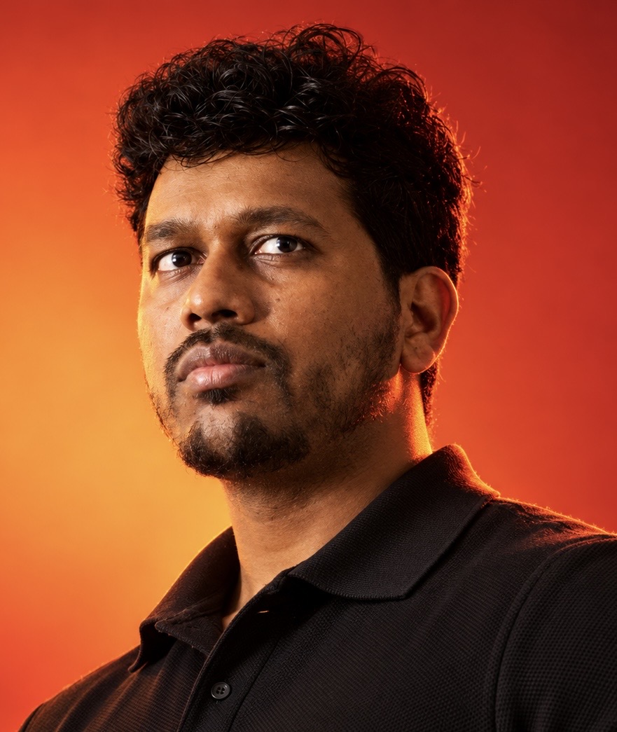 Portrait of Kiran Yenaganti against an orange and red background